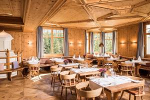 蓬特雷西纳阿布里司酒店的餐厅设有木桌、椅子和窗户。