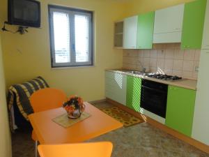 梵蒂冈角Villettemire的厨房配有绿色橱柜和桌椅