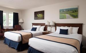 因特考斯旅行者休息汽车旅馆的酒店客房,配有两张床和椅子