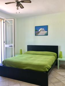 莱乌卡Casa Anter Santa Maria di Leuca的一间卧室配有一张绿色的床和吊扇
