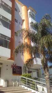 底拉斯卡拉塞尼奥丽拉特拉斯卡拉酒店的前面有棕榈树的建筑