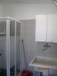 蓬塔布拉切托villetta al mare punta braccetto的一间带水槽和玻璃淋浴的浴室