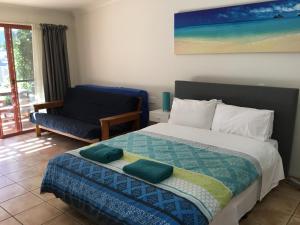 拜伦湾拜伦海滩公寓的一间卧室配有一张大床和一把椅子