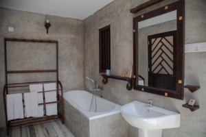平纳瓦拉宾那伟拉别墅及餐厅的一间带水槽、浴缸和镜子的浴室