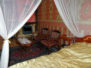 OsowiaAgroturystyka Zacisze的一间卧室配有一张床、两把椅子和一个壁炉