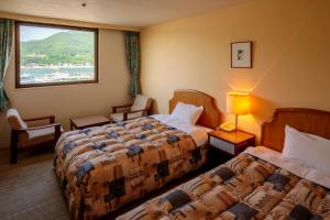 土庄町大木户酒店的酒店客房设有两张床和窗户。