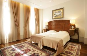 科英布拉壹贝爱瑞科酒店的一间带两张床的卧室和地毯