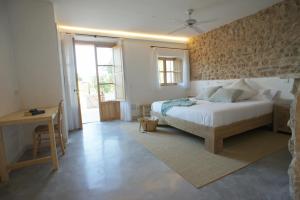 桑特略伦斯斯德斯卡尔达萨尔Ca Na Nina的一间卧室配有一张床、一张书桌和一个窗户。