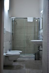 切萨雷奥港Palazzo Greco Case Vacanze的带淋浴、卫生间和盥洗盆的浴室