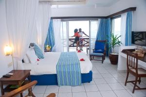 蒙巴萨航海家海滩度假酒店的酒店客房设有一张床和一个阳台。