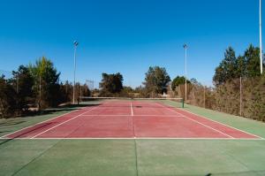 圣弗朗西斯科哈维尔Villas Paraíso de los Pinos的网球场,顶部有两盏灯