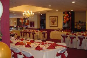 沃特敦Ramada by Wyndham Watertown Thousand的宴会厅配有白色桌子和红色餐巾