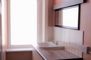 布莱克浦Foxhall Village Guest House的一间带水槽和镜子的浴室以及窗户。