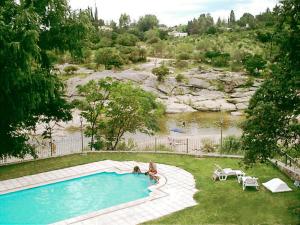 米娜克拉韦罗科斯塔塞拉纳公寓酒店的坐在河边游泳池旁的人