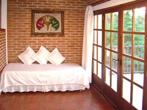 米娜克拉韦罗科斯塔塞拉纳公寓酒店的一间卧室设有一张床和砖墙