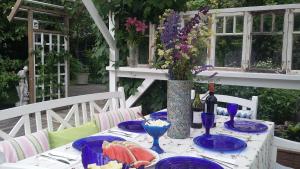 万塔Lovely Mint Garden Studio的餐桌,餐桌上放着食物盘子,花瓶上放着鲜花