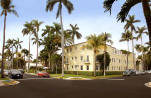 棕榈滩巴西苑酒店的一条白色的大建筑,在街上种有棕榈树