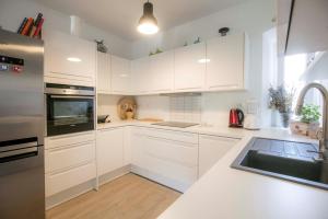 木洛希尼Season4All Apartments的白色的厨房配有白色橱柜和水槽