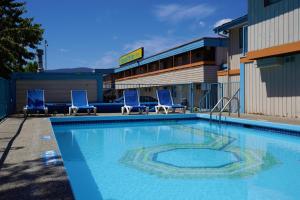 基洛纳休憩套房酒店的大楼前方的大型游泳池,配有蓝色椅子