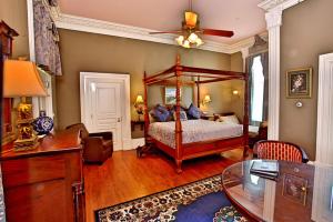 五月岬郡南方大厦住宿加早餐旅馆的一间卧室配有一张天蓬床和一张书桌