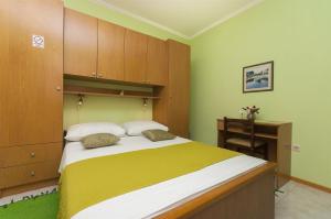 斯拉诺Rooms Vlahovic的一间卧室配有一张带木制橱柜的大床