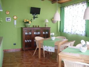 特拉比亚Le Tre Caravelle的一间拥有绿色墙壁和桌椅的用餐室