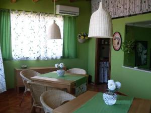 特拉比亚Le Tre Caravelle的一间拥有绿色墙壁和桌椅的用餐室