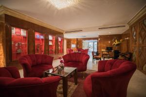安曼安曼国际酒店的客厅配有红色椅子和桌子