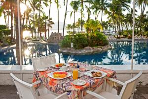 曼萨尼约哈达布里萨斯酒店的游泳池旁的餐桌,供应食物和饮料