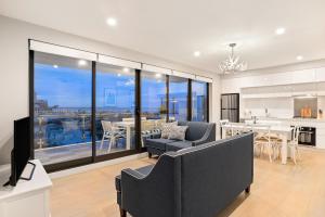 墨尔本The Hamptons Apartments - Port Melbourne的带沙发和电视的客厅以及厨房。