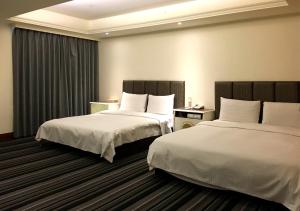 台中市瑞君商旅的两张位于酒店客房的床,配有两张sidx sidx单人床
