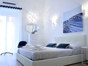 塔兰托Duca70 "Suite Home"的白色卧室设有一张大床和镜子