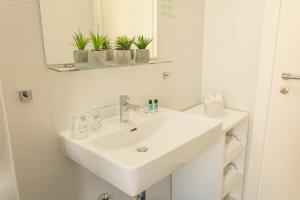 萨格勒布德尔迷你夫酒店的白色的浴室设有水槽和镜子