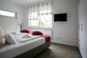 柏林Am Schmeding的一间卧室配有一张带红色枕头的床和一扇窗户