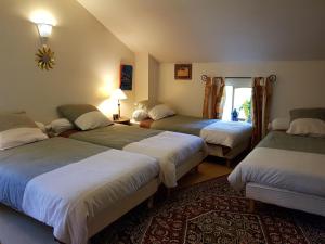 Jumeaux环岛酒店的一间卧室设有三张床和窗户。