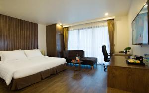 河内地球上酒店的酒店客房配有一张床、一把椅子和一张书桌