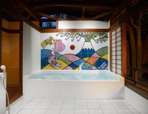 伊豆之国市伊川考优茹日式旅馆的浴室配有壁画和浴缸