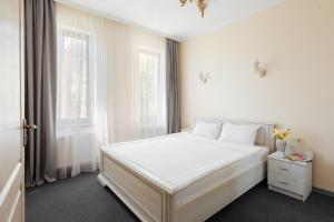 敖德萨阿西叶宾馆的白色卧室设有白色的床和2个窗户