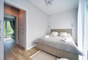 波别罗沃Apartamenty Sun Seasons 24 - Four Seasons的一间白色的卧室,配有床和门