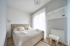 波别罗沃Apartamenty Sun Seasons 24 - Four Seasons的白色的卧室设有床和窗户