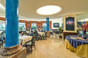 博尔塞纳Hotel Columbus sul Lago的餐厅设有桌椅和蓝色柱子
