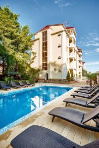 阿德勒黑海旅馆的一座带躺椅的游泳池位于大楼旁