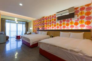 盐寮浪花一朵朵民宿  的酒店客房设有两张床和彩色墙壁。