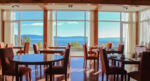 埃尔卡拉法特特拉萨斯德尔卡拉法特酒店的餐厅设有桌椅和大窗户。
