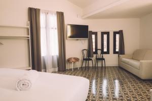 曼雷沙Hotelet Casa Padró的酒店客房配有床、沙发和桌子。