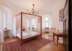 卡尔明茨Schloss Raitenbuch的一间卧室配有一张天蓬床和一张桌子