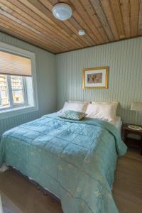 雷讷萨利索奥斯丁公寓的卧室内的一张床铺,设有木制天花板