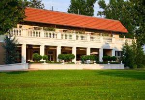 贝凯什乔包Arcanum Hotel的一座白色的建筑,有橙色的屋顶和院子