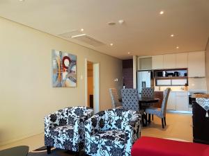 巴利托Zimbali Suites 301的客厅配有两把椅子和一张桌子