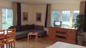佩尔沃姆Hotel Landhaus Leuchtfeuer Nordseeinsel Pellworm的带沙发和电视的客厅